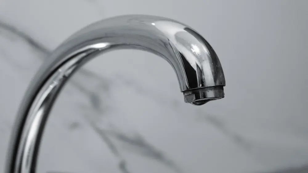 Хромиран кран над мивка, от който не тече вода