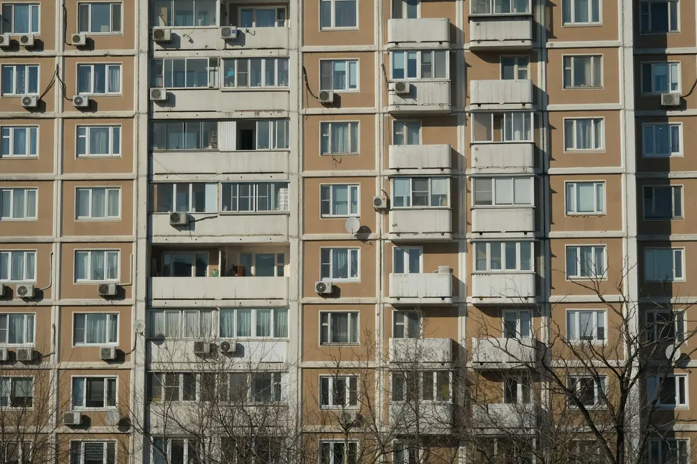 Фасада на многоетажен панелен блок с балкони и климатици