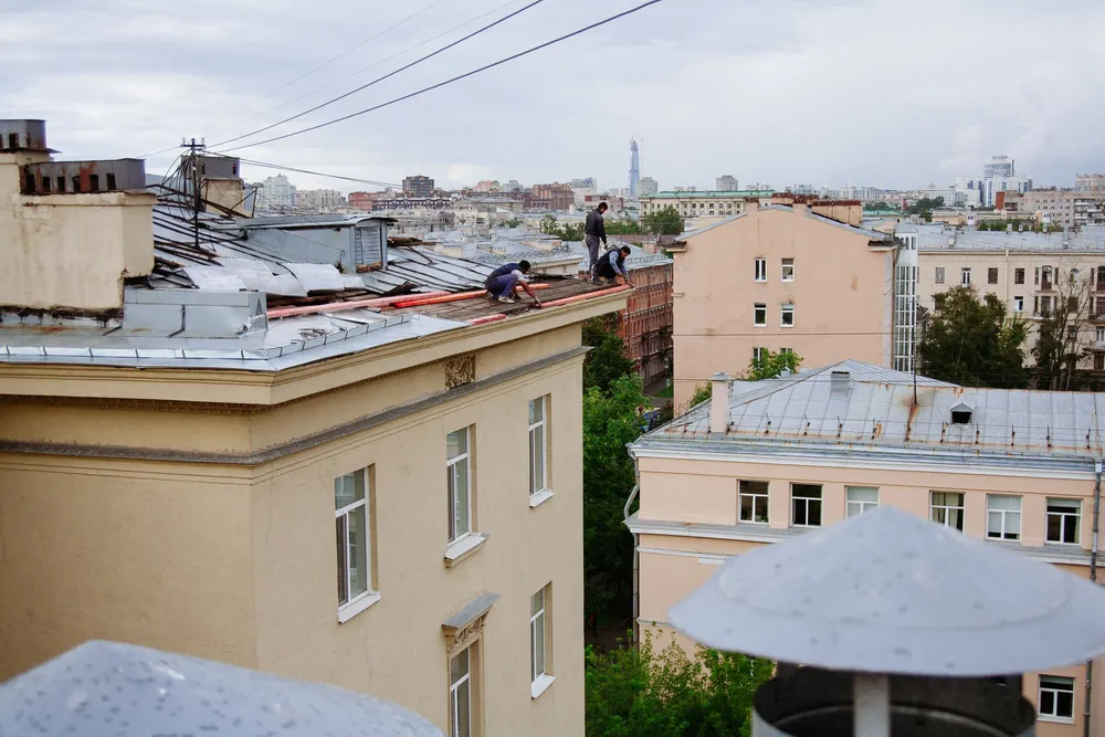 Майстори работят по покрива на жилищна сграда